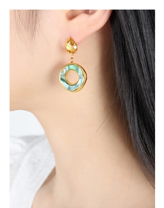 Detailed view of model wearing a 18K gold plated geometric resin earring with marble texture