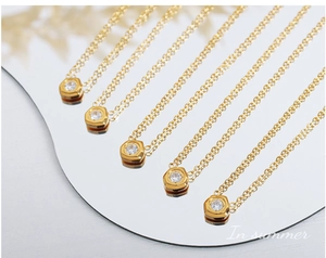 Macro view of six gold necklaces with hexagonal zircon pendants on a mirror base