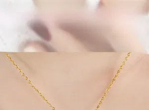 Nahaufnahme einer zarten goldenen Hasenkette am Hals eines Models im Detail
