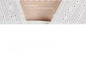 Detailed macro view of white lace crochet pattern on a premium cotton fabric blouse