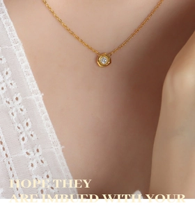 Detail of a gold meteorite-shaped pendant necklace with cubic zirconia on a female neck