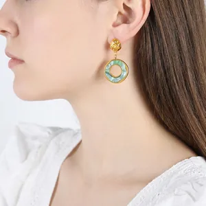 French vintage earrings with green resin and 18K gold plated circles on a model