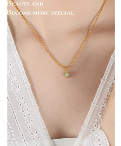 Détail d'un collier vintage doré avec pendentif en pierre bleu clair sur dentelle