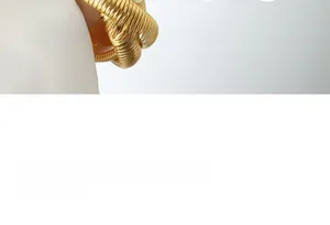 Detail of a gold plated stainless steel triple layer spiral serpent bracelet with texture