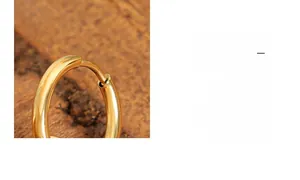 Macro di orecchini a cerchio a cuore dorati lucidi su una superficie in legno naturale