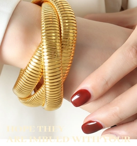 Close-up of gold-plated triple-layer snake-style wrap bracelet on model's wrist