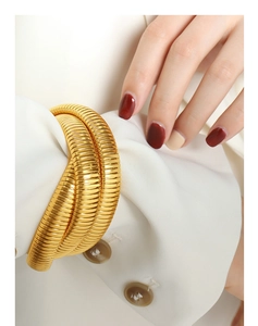 Macro shot of gold-plated triple-layer snake chain bracelet on a model's wrist