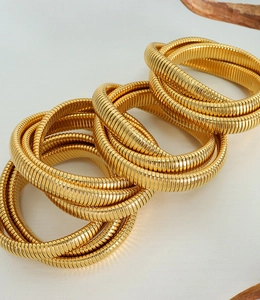 Macro view of gold-plated stainless steel snake bone bracelets with metallic texture