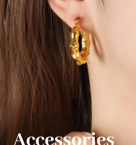 Close-up of 18K gold plated hoop earrings with bamboo texture on a female model