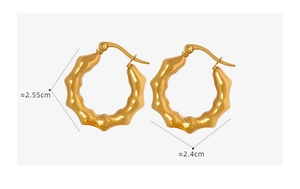 Detail shot of golden C-shaped hoop earrings with dimensions 2.55cm by 2.4cm