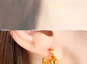 Close-up of vintage geometric C-shaped 18K gold plated earrings worn by a model