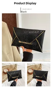 Detail of black envelope clutch featuring embossed snakeskin texture and gold metal accents