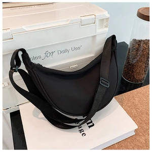 Detail of black nylon crescent bag with adjustable wide strap in minimalist daily setting