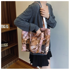 Detail of canvas tote bag featuring vintage patchwork print and contrast pink-brown handles