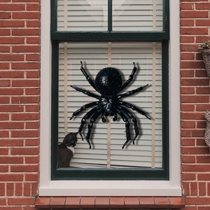 Realistische gigantische zwarte spin raamsticker op bakstenen muur met kat op de achtergrond