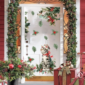 Detail of Christmas cat wall sticker with holly leaves on white door background