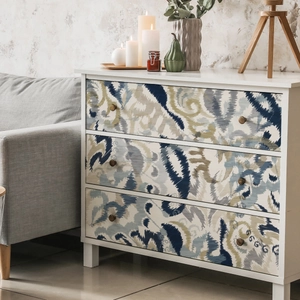 Detail view of modern white dresser with three patterned drawers and vintage bronze handles