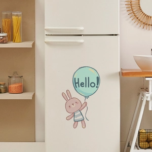 Detailed view of luminous rabbit sticker with balloon on a white refrigerator surface
