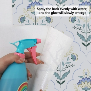 Detailed view of water-activated adhesive floral wallpaper being sprayed for application
