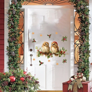 Detailed view of hand-painted Christmas owl wall decals on a white door with holiday decor