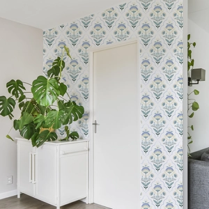 Detail of floral self-adhesive wallpaper in a hallway with green plants and white door