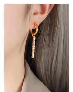 Close-up of 18K gold-plated drop earrings with zircon square bar on model's ear