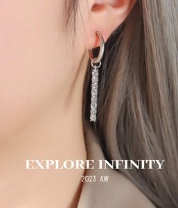 Close-up of geometric silver dangle earrings with sparkling cubic zirconia on a model
