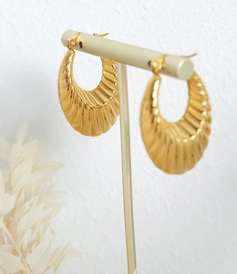 Détail macro de boucles d'oreilles en U plaquées or avec motifs à vagues texturés