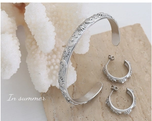 Detailed relief patterns of sun, moon, and stars on silver cuff bracelet and earrings