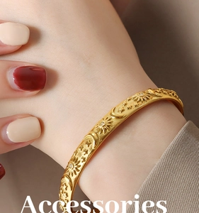 Detail of gold-plated bangle with sun moon star relief and cubic zirconia accents