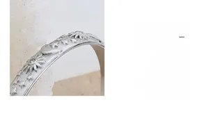 Macro detail of matte silver ring with celestial sun moon and star embossed patterns