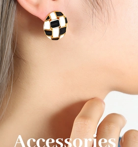 Close-up of checkered enamel oval stud earrings with golden trim on a model