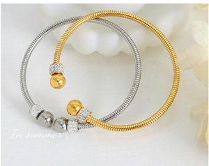 Detail of gold and silver spring bracelets with spiral texture and paved crystal beads