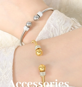 Close-up of gold and silver snake chain cuff bracelets with rhinestones on a model wrist