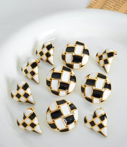 Detail shot of vintage heart and round checkerboard enamel earrings with gold plating