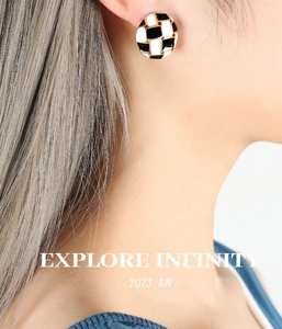 Close-up of a model wearing a gold-edged checkerboard heart earring for women