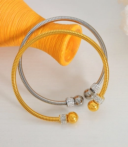 Detailed close-up of gold and silver snake chain bracelets with sparkling rhinestones