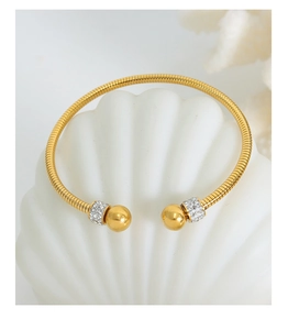Detail of gold-plated snake bone textured open bangle with sparkling crystal beads