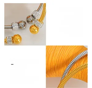 Detail of 18K gold plated titanium steel open bangle with sparkling pave zircon spheres