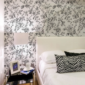 Detail view of monochrome floral vintage wallpaper in a modern minimalist bedroom setting