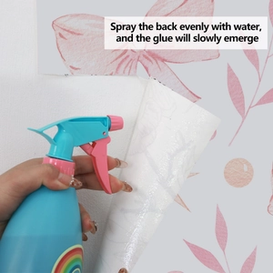 Close-up showing how to spray water on water-activated floral wallpaper adhesive