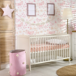 Detailed view of vintage pink floral and butterfly wallpaper in a cozy nursery setting