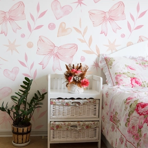 Detail of pink bow and heart wall decals in a cozy, hand-painted style girl bedroom