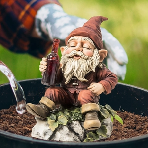 Creative garden gnome figurine holding a wine bottle on a rock base for yard decoration