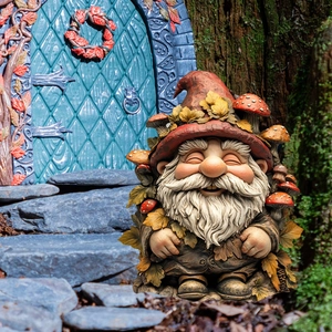 Garden gnome statue with red mushroom hat and white beard in fairy garden scene