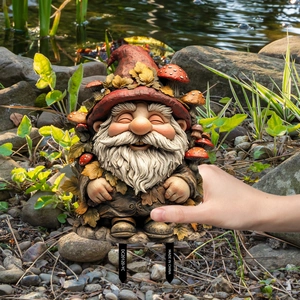 Garden gnome decorative stake featuring a red hat and mushrooms in a natural setting