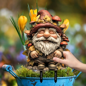 Garden gnome stake with red mushroom hat placed in a mossy bucket for outdoor decor