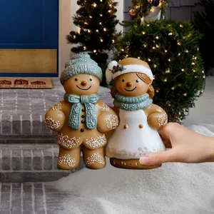 Detail showing a pair of Christmas gingerbread man garden stakes with snowy textures