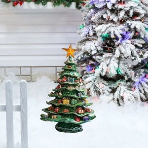 Close-up of a glossy green ceramic Christmas tree with colorful gift boxes and a gold star