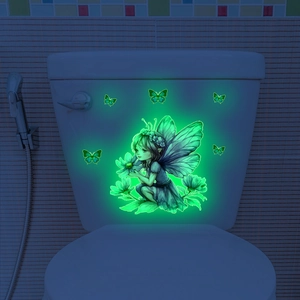 Adesivo murale fluorescente con fata e farfalle verdi luminose in una stanza buia